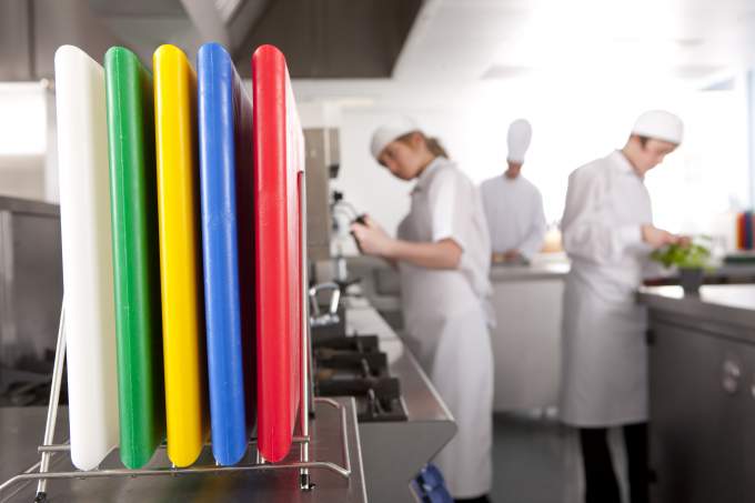 Tablas de cortar de plástico codificadas por colores en una cocina profesional